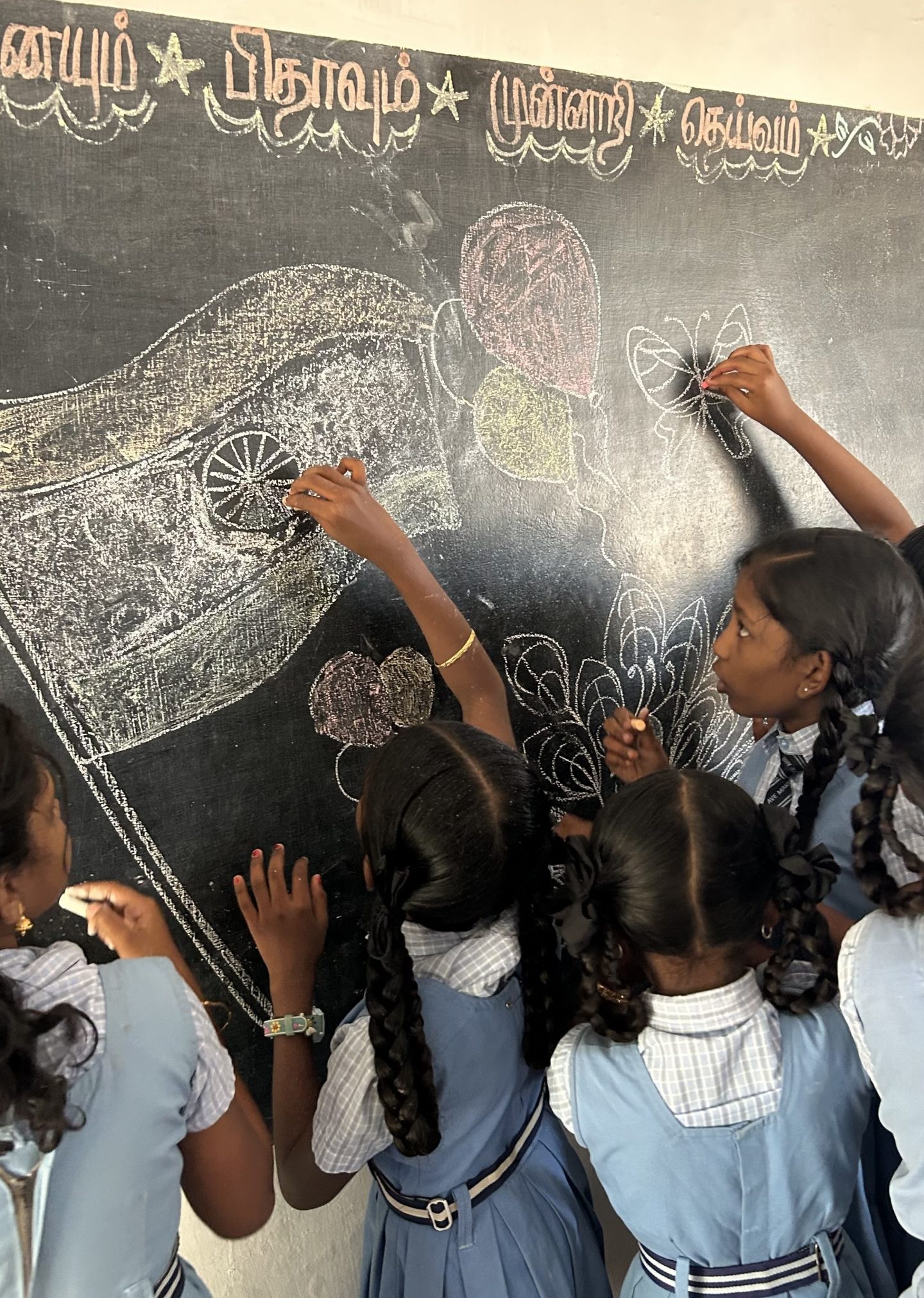 Students drawing the Indian flag on the board