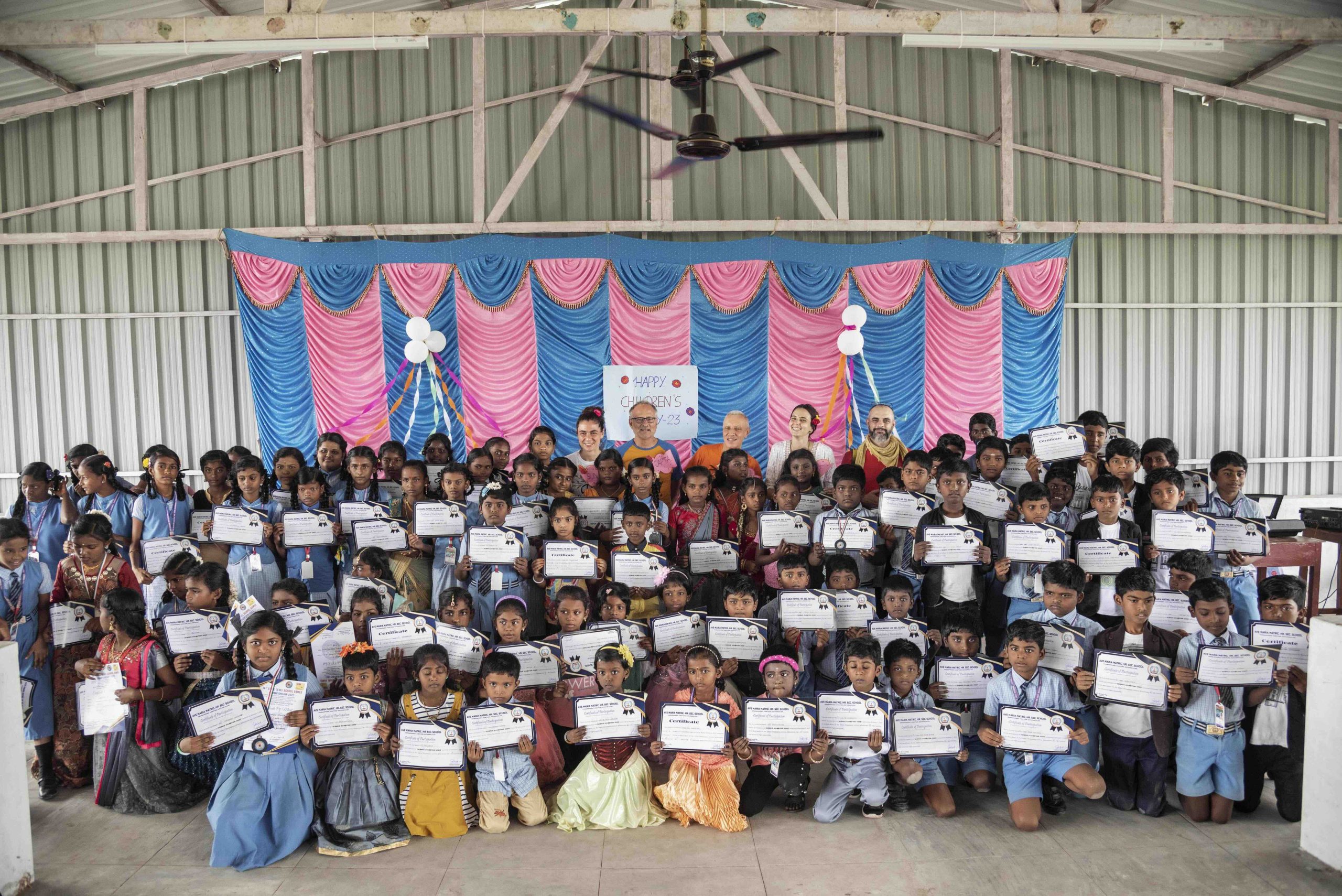 Ave Maria School students holding their certificates and posing for a photo with Energia volunteers on Children's Day