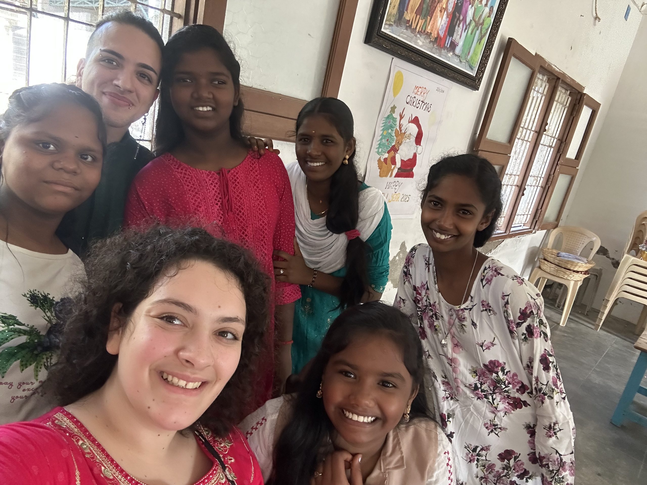 Francesca and Matthew, volunteering for Energia, taking pictures with girls at Island of Hope