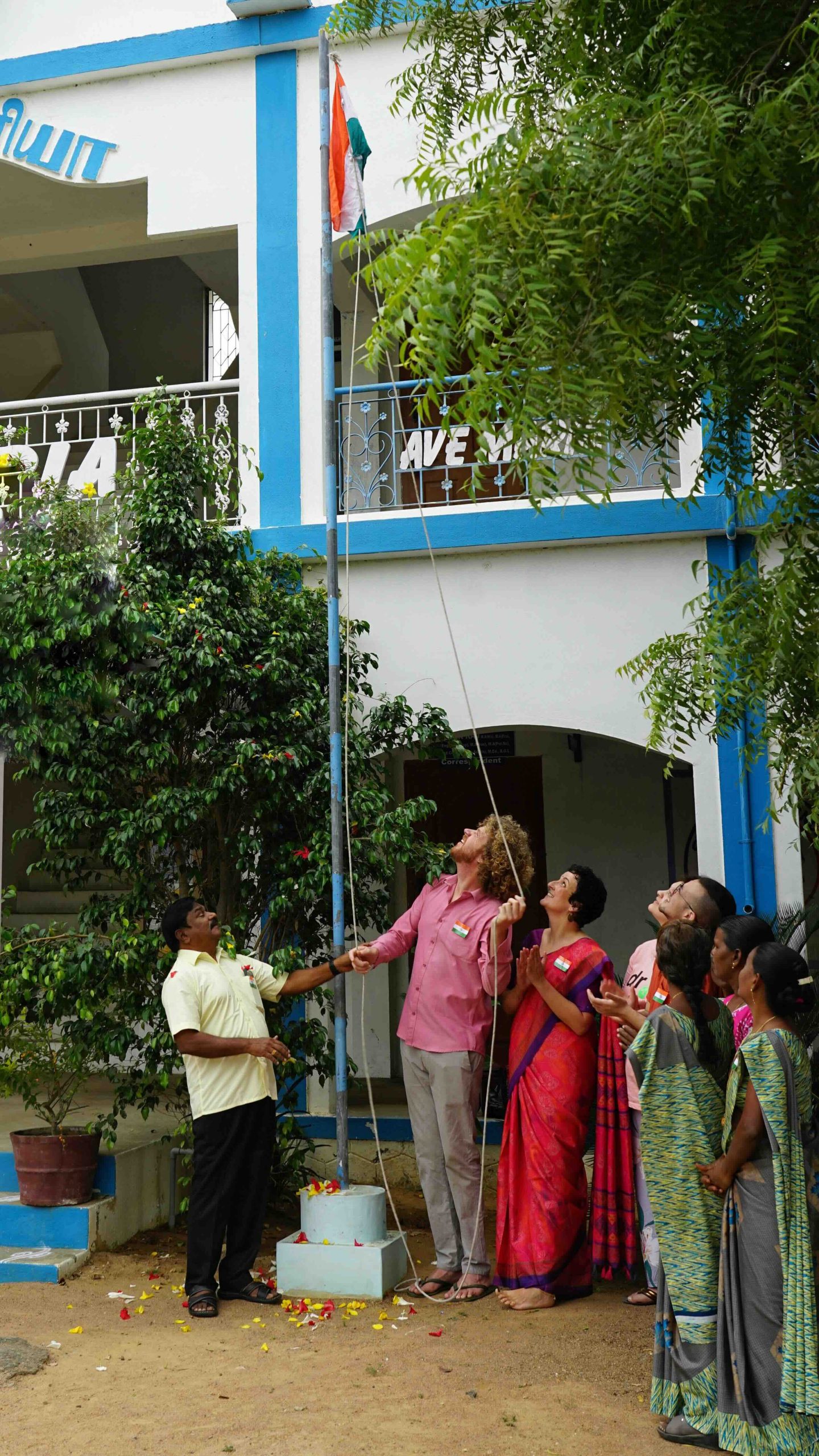 General Secretary Peter Raj, volunteers Willelm and Valerie, Francesca and Matthew, volunteering for Energia, and local staff hoisting the Indian flag on Republic Day