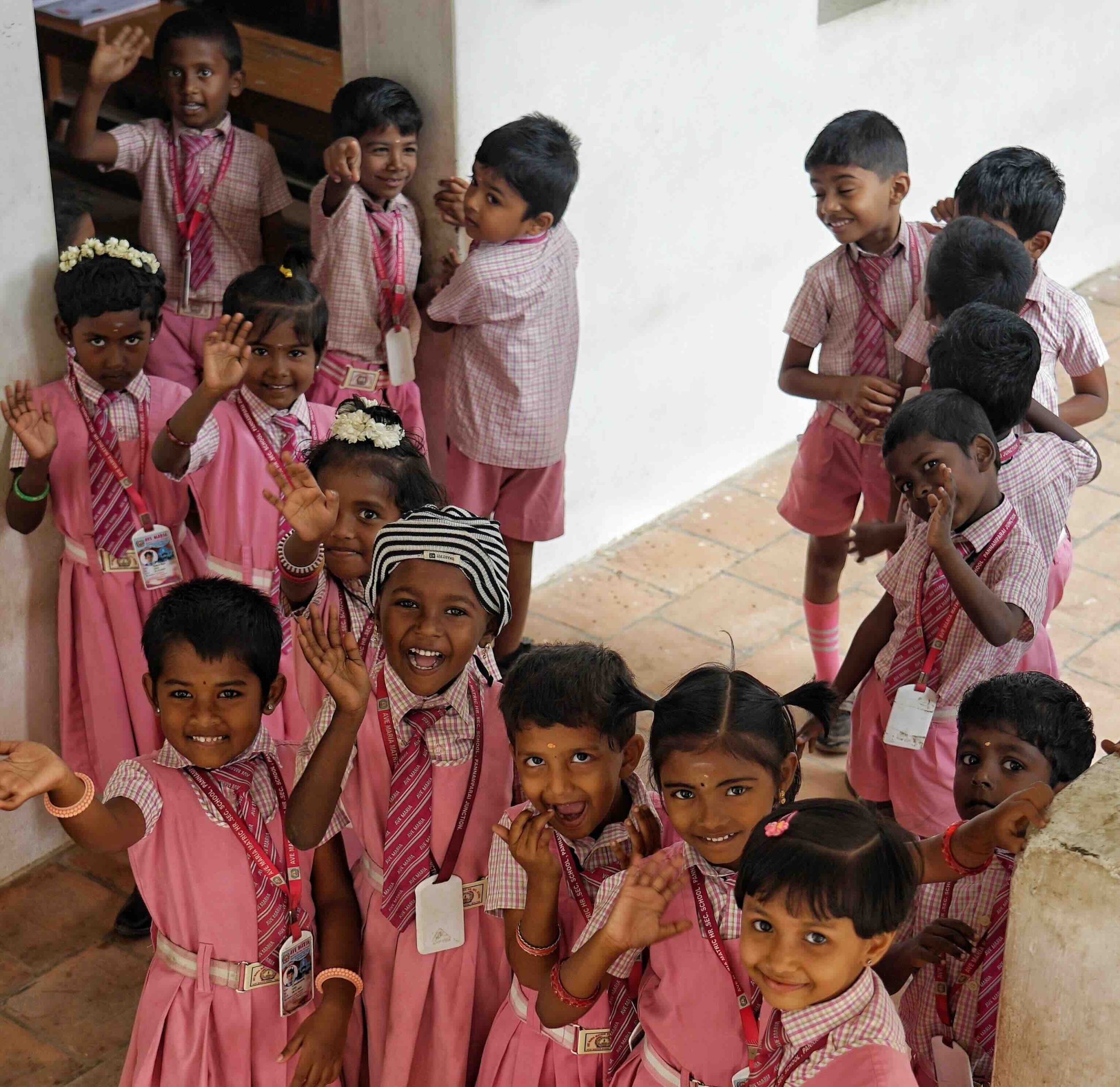 Kindergarten students waving and smiling at the camera