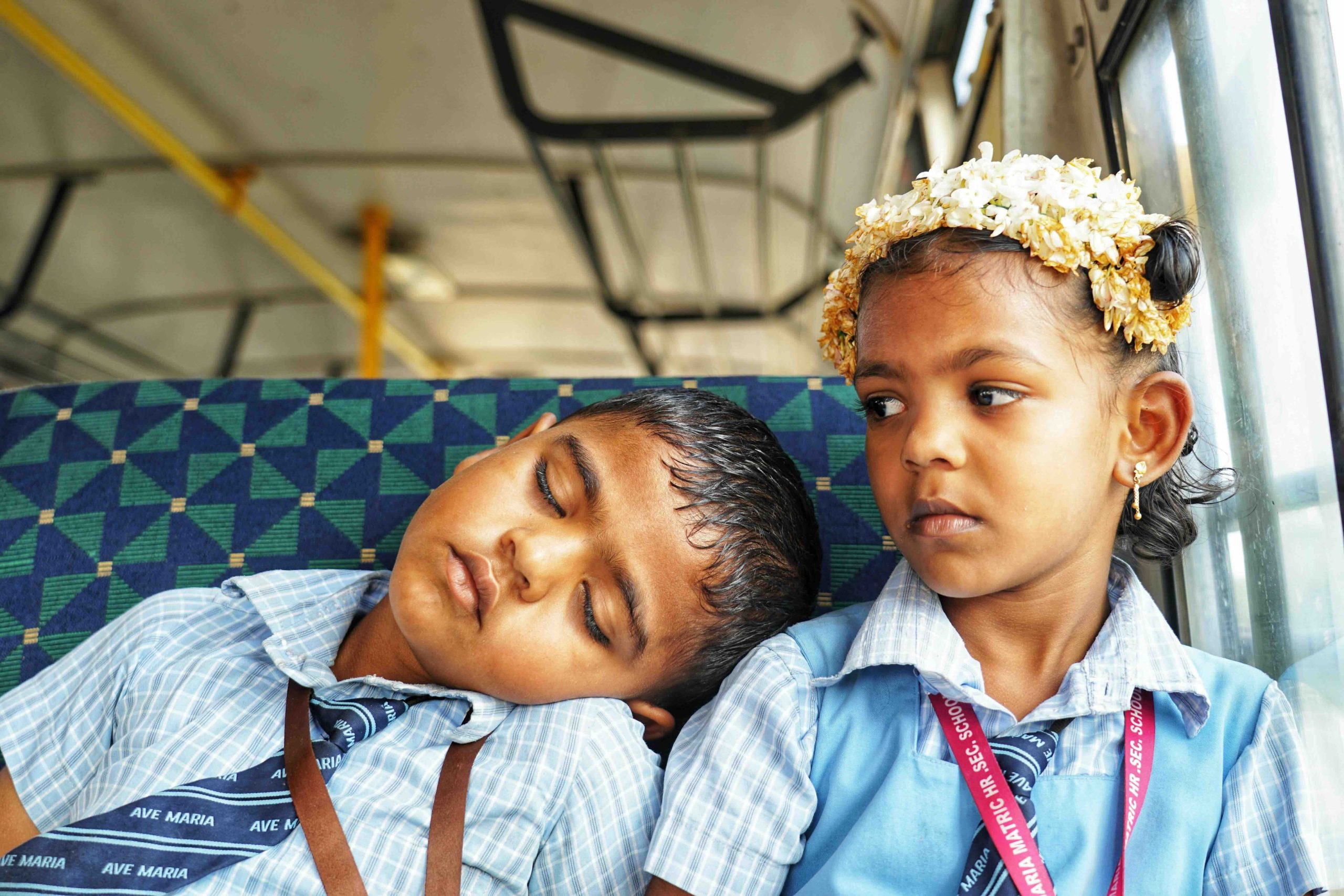 Primary students resting on the bus after a long day at school
