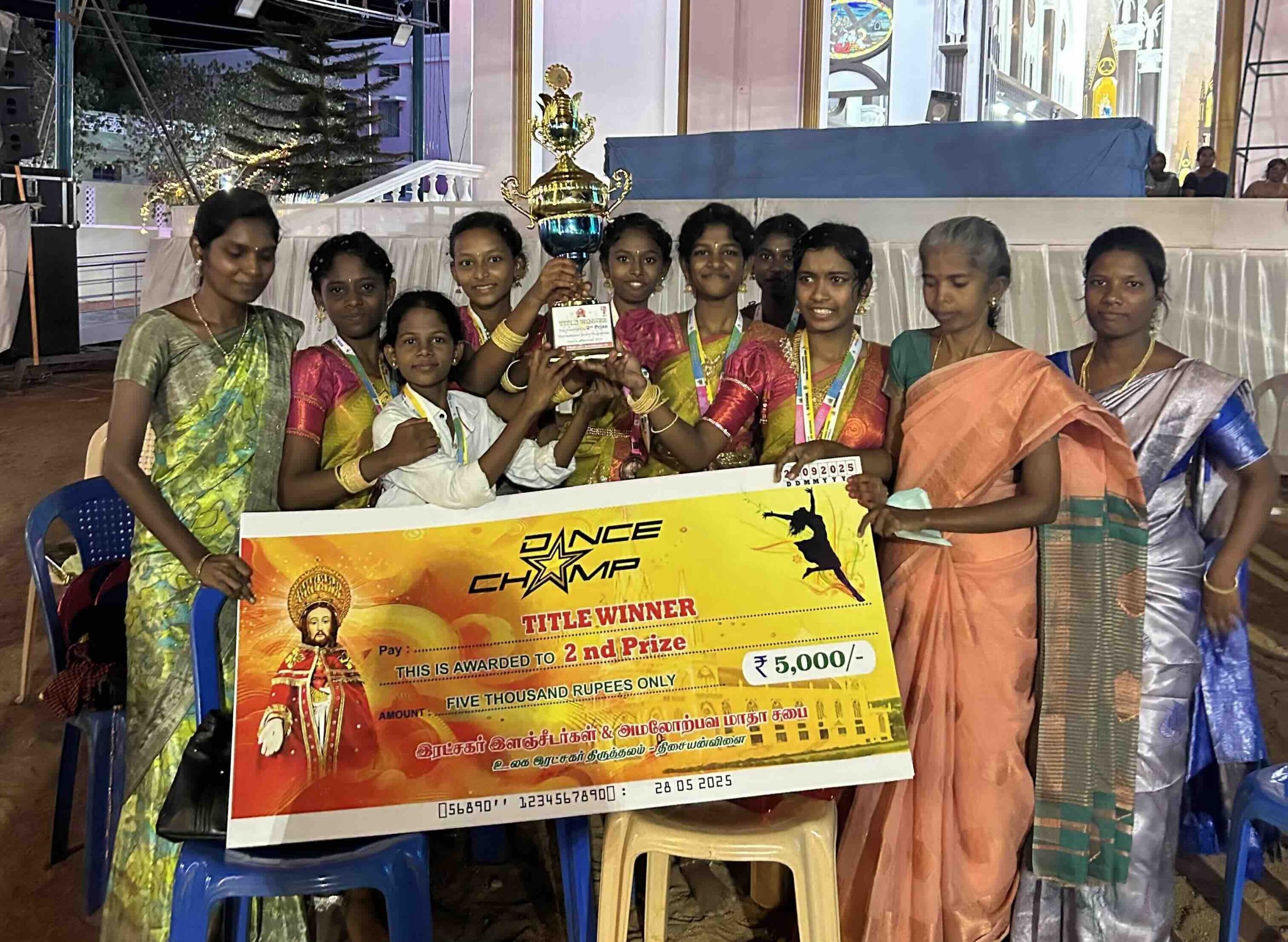 Students, teachers, and the principal celebrate securing second place in a local dance competition with their trophy and giant check