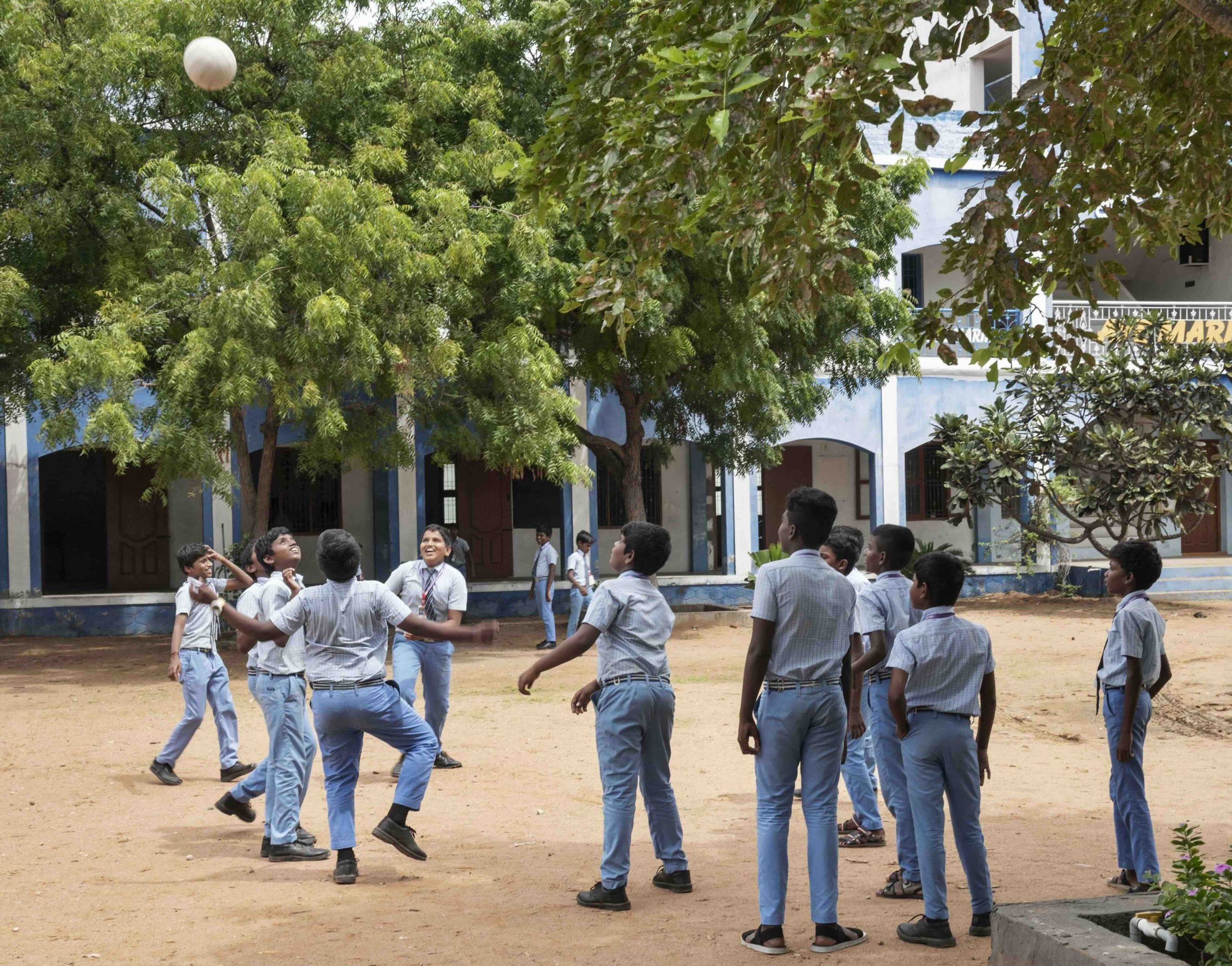 Students playing volleyball in the school playground